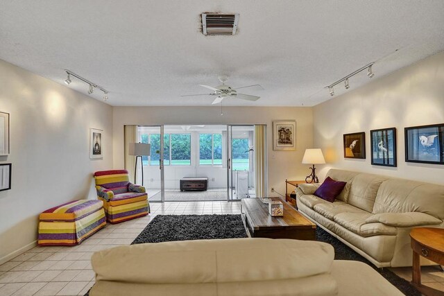 living room featuring visible vents, a ceiling fan, baseboards, rail lighting, and light tile patterned floors