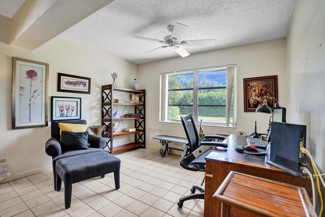 office space featuring baseboards, a textured ceiling, ceiling fan, and light tile patterned floors