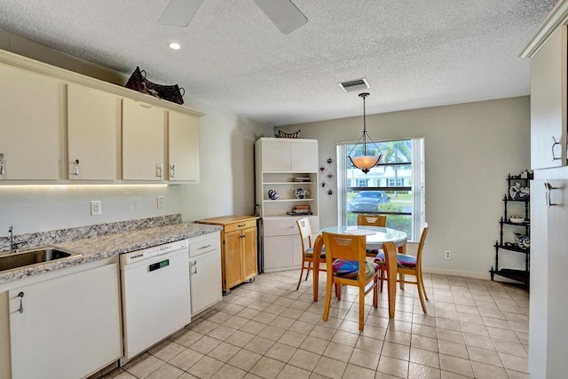 kitchen featuring visible vents, white dishwasher, ceiling fan, light countertops, and a sink
