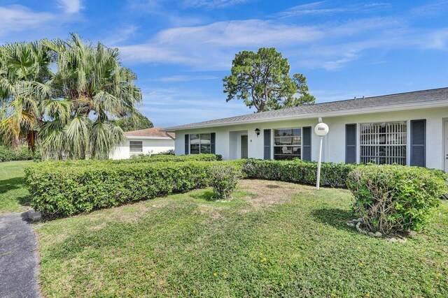 single story home with a front lawn and stucco siding