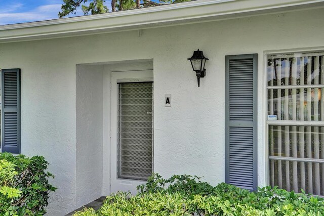 entrance to property featuring stucco siding