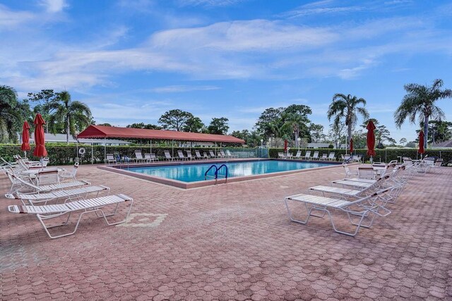 pool with a patio and fence