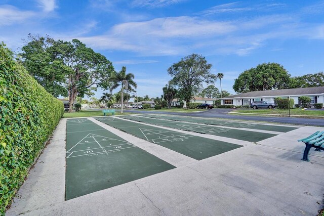 view of community featuring uncovered parking and shuffleboard