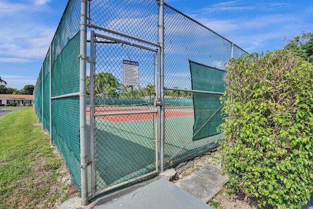 view of sport court featuring fence and a gate