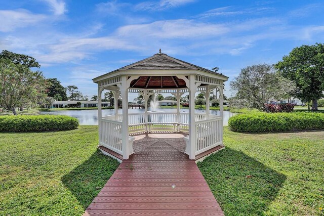 dock area with a water view, a gazebo, and a yard