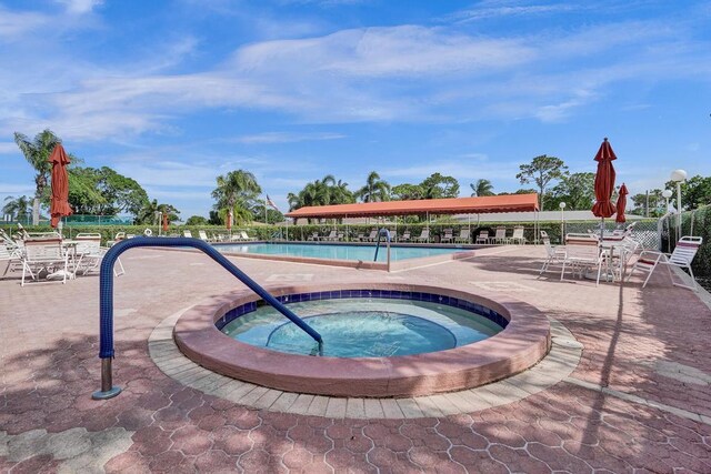 community pool with a patio and a community hot tub