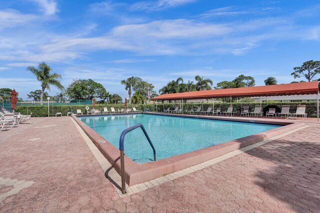 community pool with fence and a patio area