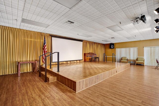 cinema room with wood finished floors and visible vents