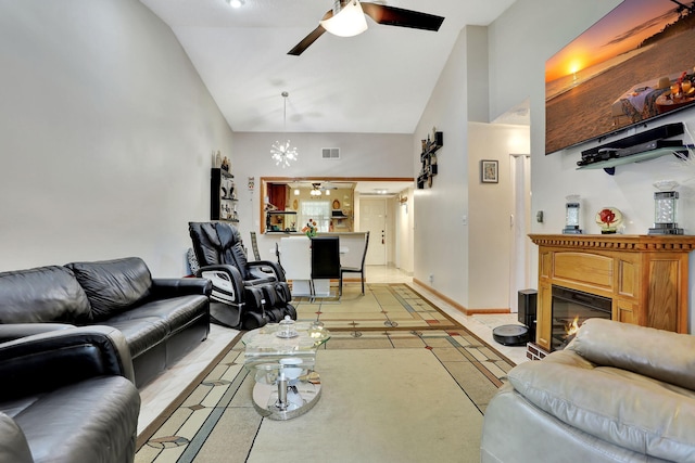 living area with visible vents, high vaulted ceiling, a ceiling fan, and a glass covered fireplace