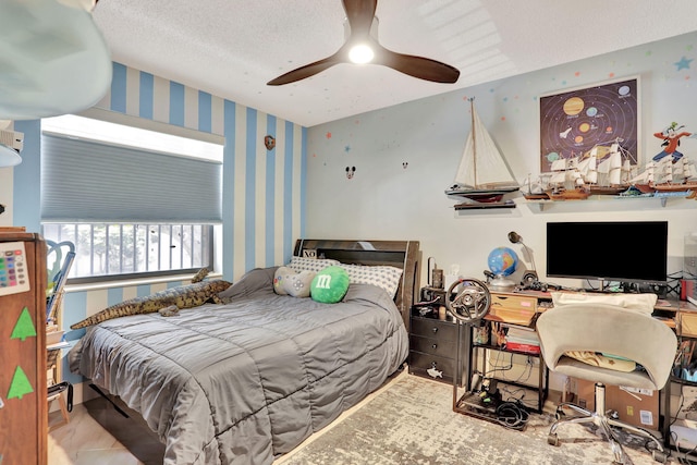 bedroom with ceiling fan and wallpapered walls