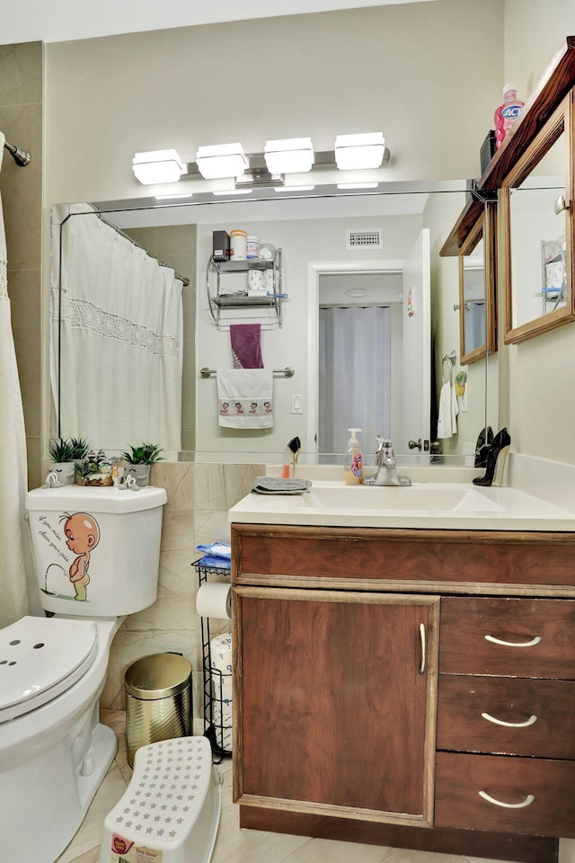 bathroom with a shower with curtain, tile walls, toilet, vanity, and visible vents