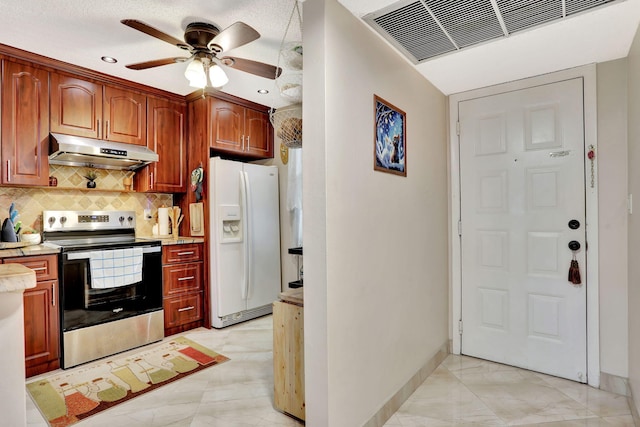 kitchen with white fridge with ice dispenser, under cabinet range hood, light countertops, stainless steel electric range, and visible vents