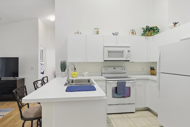 1054 NW Tuscany Dr, Port Saint Lucie, FL 34986 - kitchen featuring a kitchen breakfast bar, a sink, light countertops, white appliances, and a peninsula
