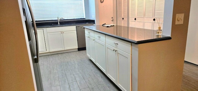 2006 S Federal Hwy S Unit 102, Boynton Beach, FL 33435 - kitchen with white cabinetry, dark countertops, a sink, and dishwasher