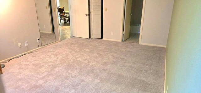 2006 S Federal Hwy S Unit 102, Boynton Beach, FL 33435 - unfurnished bedroom with baseboards, carpet flooring, and connected bathroom