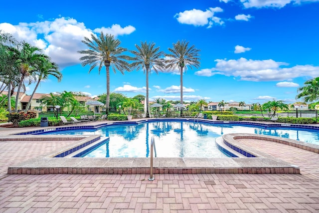 community pool featuring a patio and fence
