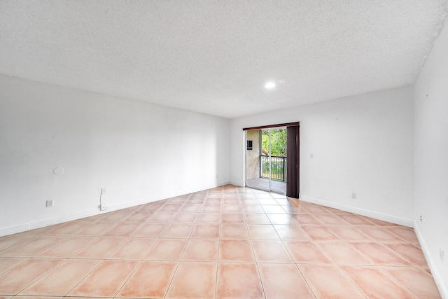 spare room featuring baseboards, recessed lighting, and a textured ceiling