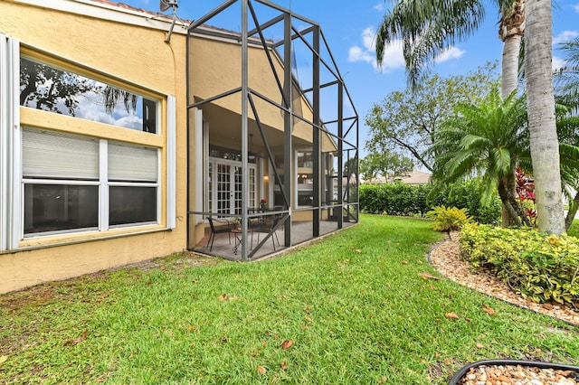 view of green lawn featuring a patio area and glass enclosure