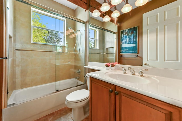 bathroom featuring toilet, vanity, bath / shower combo with glass door, and tile patterned floors