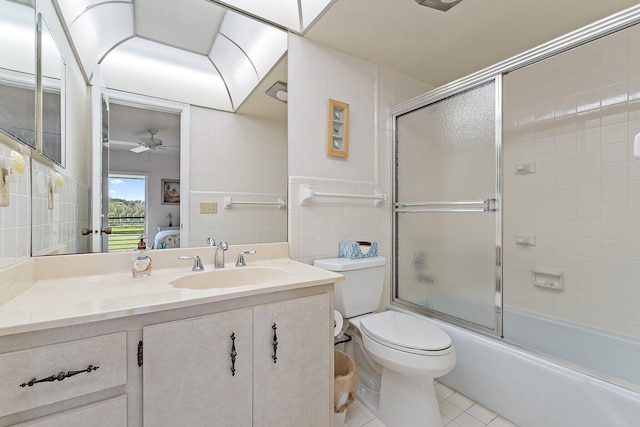 bathroom featuring ceiling fan, tile walls, vanity, tile patterned floors, and toilet