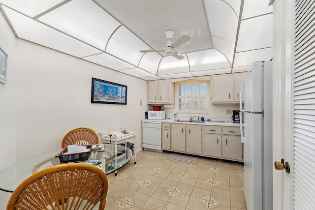 kitchen with light countertops, a sink, ceiling fan, and white appliances