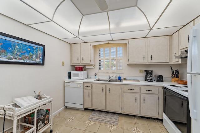 kitchen featuring a sink, light countertops, baseboards, under cabinet range hood, and white appliances