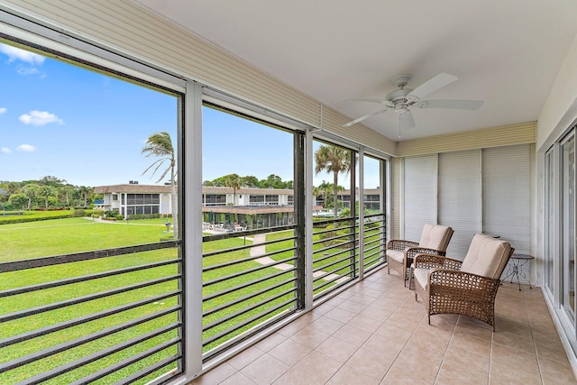 sunroom / solarium with ceiling fan and a residential view