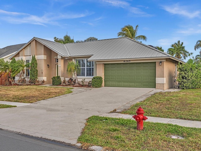 single story home with stucco siding, an attached garage, driveway, and a front yard