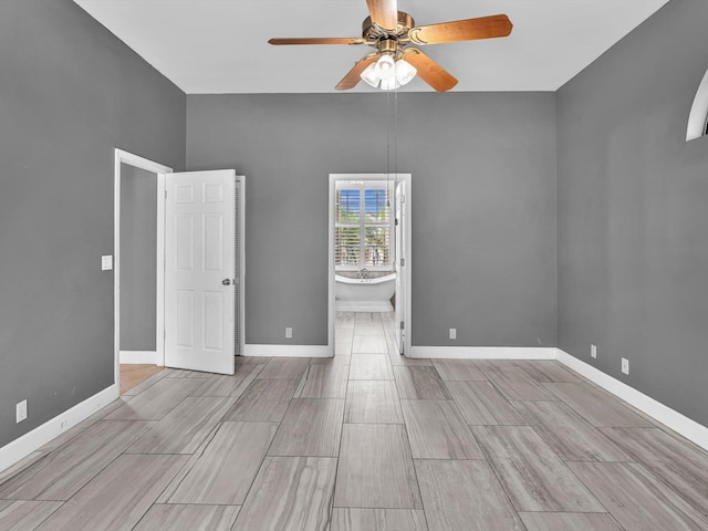 empty room with baseboards, ceiling fan, and wood finished floors