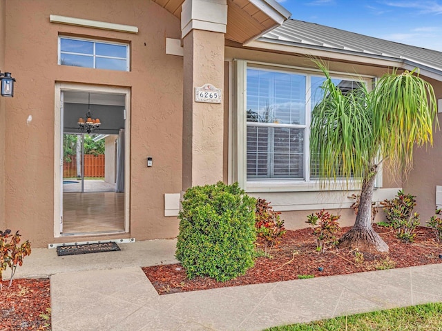 property entrance featuring a standing seam roof and stucco siding