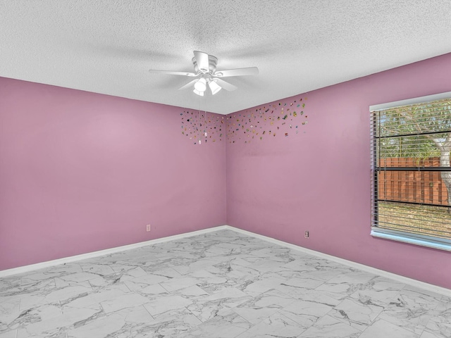 empty room featuring baseboards, a ceiling fan, a textured ceiling, and marble finish floor