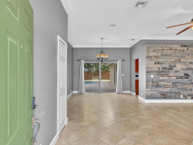 foyer featuring baseboards, visible vents, ornamental molding, and ceiling fan with notable chandelier