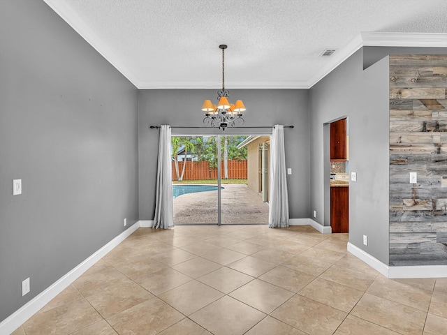 unfurnished dining area with crown molding, light tile patterned flooring, a notable chandelier, a textured ceiling, and baseboards