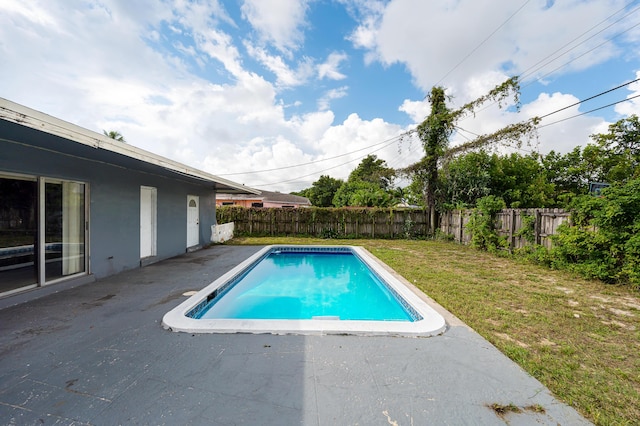 view of swimming pool with a lawn, a patio, and a fenced backyard