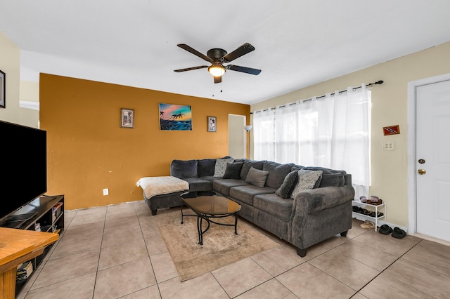 living room featuring light tile patterned floors, ceiling fan, and a fireplace