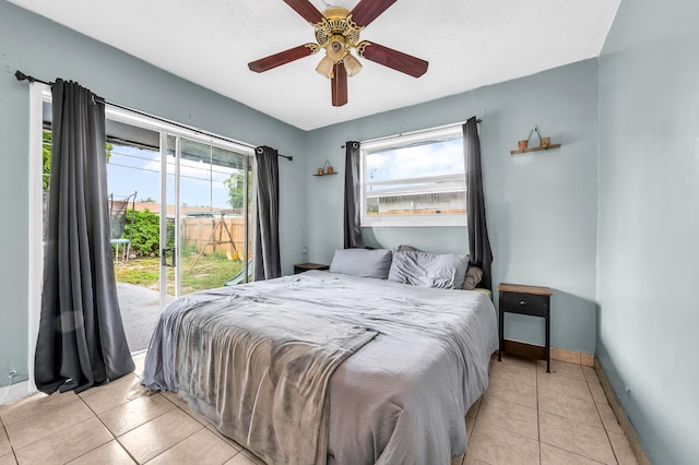 tiled bedroom with baseboards, access to exterior, and multiple windows