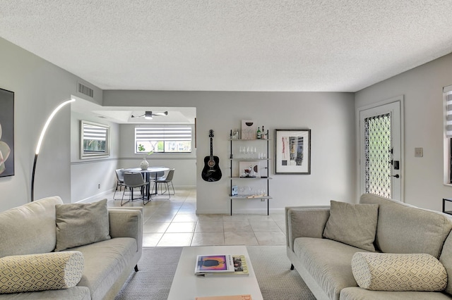 15108 Ashland Dr Unit 185, Delray Beach, FL 33484 - living room with light tile patterned floors, a ceiling fan, visible vents, and a textured ceiling