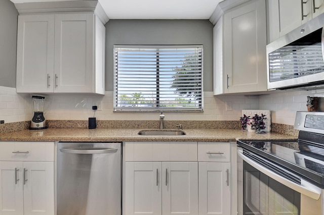15108 Ashland Dr Unit 185, Delray Beach, FL 33484 - kitchen featuring appliances with stainless steel finishes, tasteful backsplash, white cabinets, and a sink