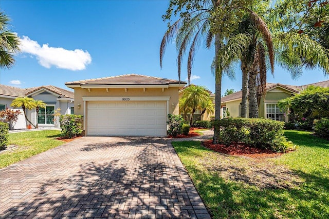 9925 SW Stonegate Dr, Port Saint Lucie, FL 34987 - view of front facade featuring stucco siding, decorative driveway, a garage, a front yard, and a tiled roof