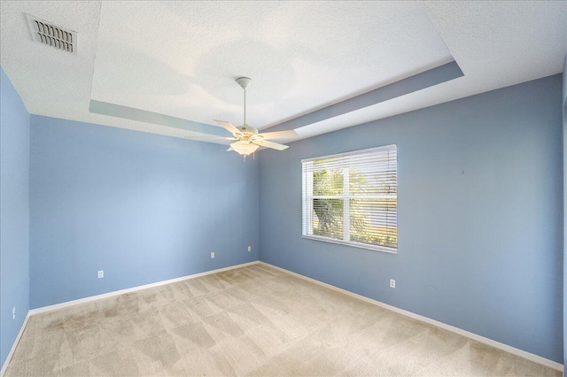9925 SW Stonegate Dr, Port Saint Lucie, FL 34987 - carpeted empty room with a tray ceiling, a textured ceiling, ceiling fan, and baseboards