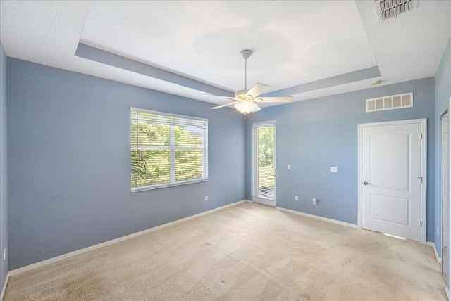 9925 SW Stonegate Dr, Port Saint Lucie, FL 34987 - empty room featuring a raised ceiling, a textured ceiling, light carpet, and baseboards