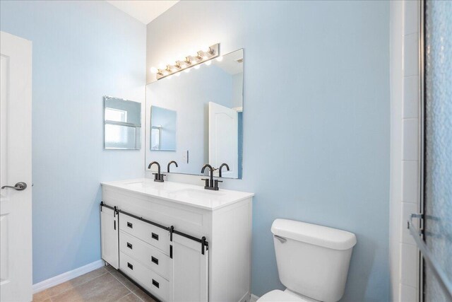 9925 SW Stonegate Dr, Port Saint Lucie, FL 34987 - full bathroom with double vanity, toilet, tile patterned flooring, and baseboards