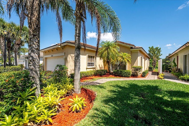 9925 SW Stonegate Dr, Port Saint Lucie, FL 34987 - view of front of home with stucco siding, a front yard, and a garage