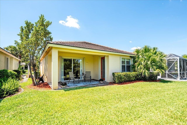 9925 SW Stonegate Dr, Port Saint Lucie, FL 34987 - rear view of property featuring stucco siding, a yard, and a patio area