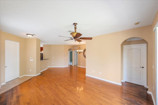 9925 SW Stonegate Dr, Port Saint Lucie, FL 34987 - empty room with arched walkways, a ceiling fan, wood finished floors, and baseboards