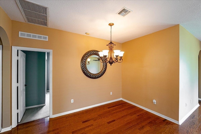 9925 SW Stonegate Dr, Port Saint Lucie, FL 34987 - spare room with arched walkways, wood finished floors, baseboards, and a chandelier