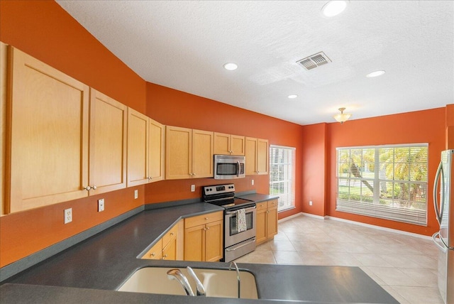 9925 SW Stonegate Dr, Port Saint Lucie, FL 34987 - kitchen featuring appliances with stainless steel finishes, light brown cabinets, baseboards, dark countertops, and light tile patterned floors