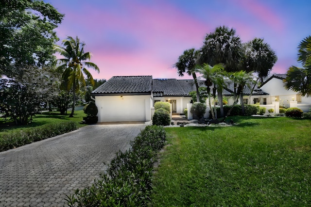 14 Windsor Ln, Boynton Beach, FL 33436 - view of front facade featuring decorative driveway, stucco siding, an attached garage, a tiled roof, and a lawn