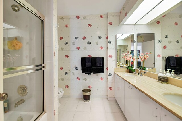 14 Windsor Ln, Boynton Beach, FL 33436 - bathroom featuring toilet, double vanity, tile patterned flooring, and enclosed tub / shower combo