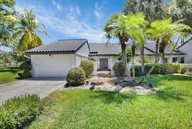14 Windsor Ln, Boynton Beach, FL 33436 - view of front facade featuring stucco siding, a tiled roof, decorative driveway, an attached garage, and a front yard